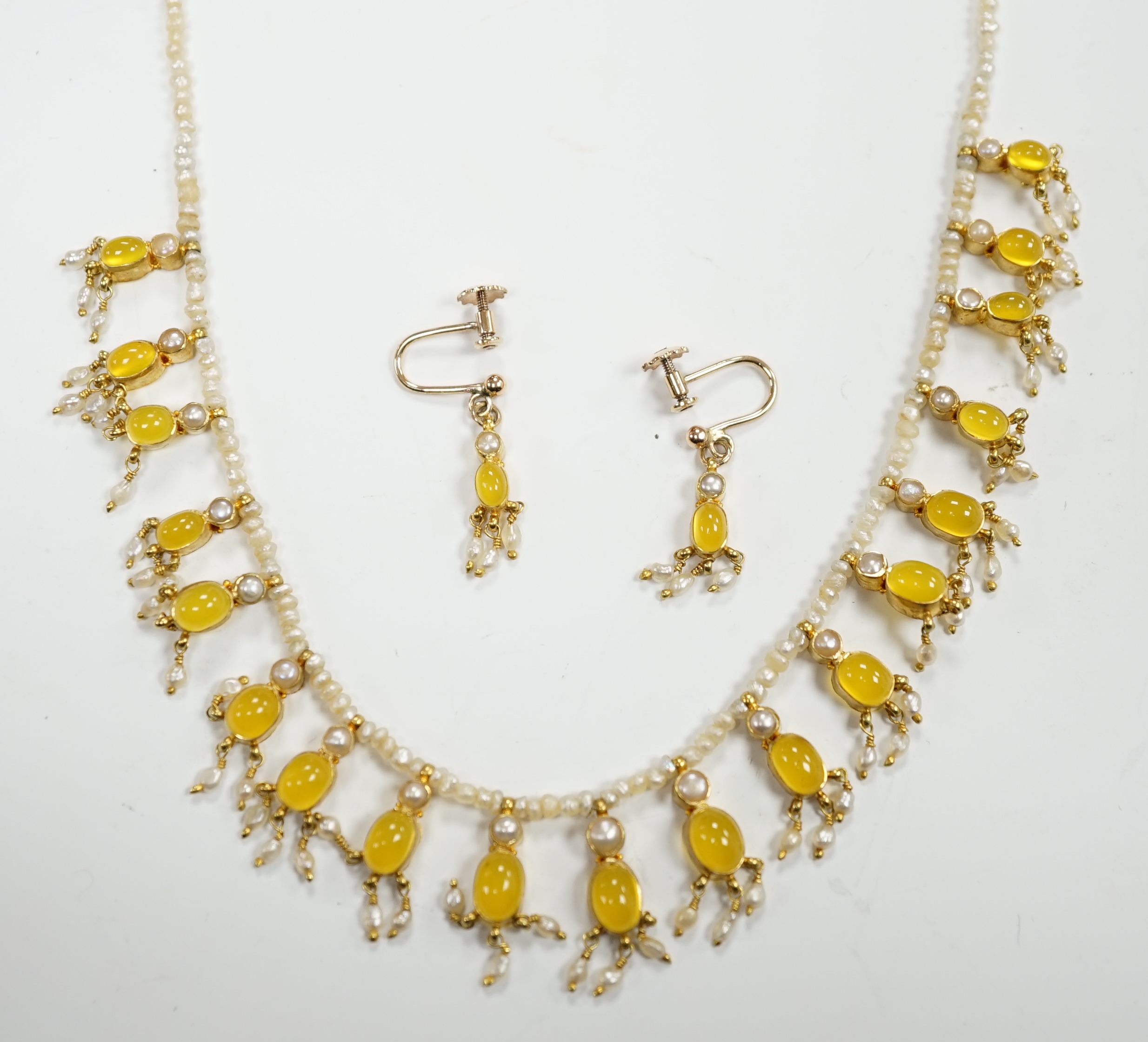 An early 20th century seed pearl and yellow chalcedony set drop necklace with yellow metal clasp, 38cm. and a pair of matching drop ear clips, stamped 375.